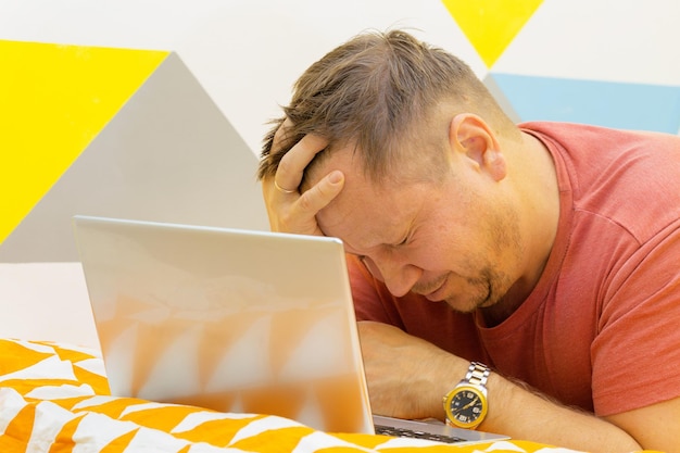 Man on the bed working on a laptop. human emotions