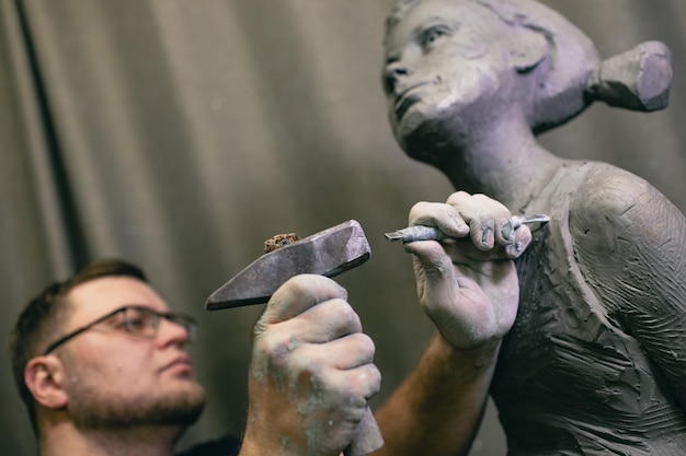 Man beeldhouwer maakt beeldhouw buste menselijke vrouw sculptuur standbeeld ambachtelijke creatie workshop