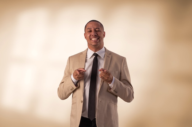 Man in beige business suit in studio photo on a background with lights.