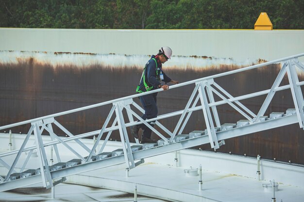 Man beklim de trap opslag dak visuele inspectie tankolie