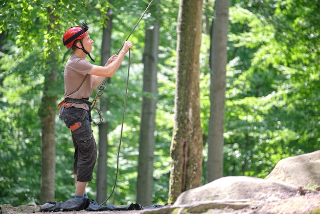 L'uomo assicura il suo compagno di arrampicata con dispositivo di assicurazione e corda. handman dello scalatore che tiene l'attrezzatura per la sicurezza dell'alpinismo su roccia.