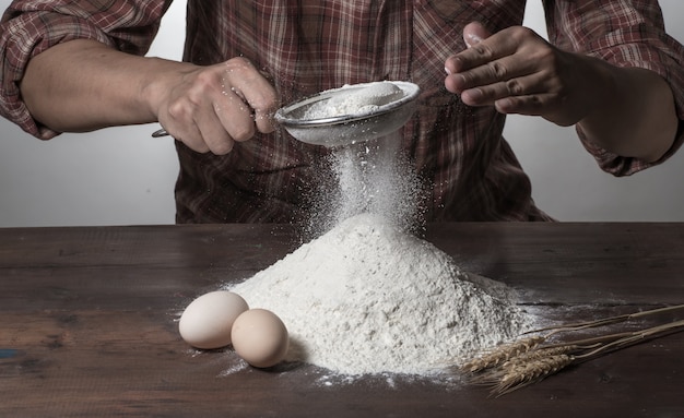 Man bereidt brooddeeg op houten tafel in een bakker close-up