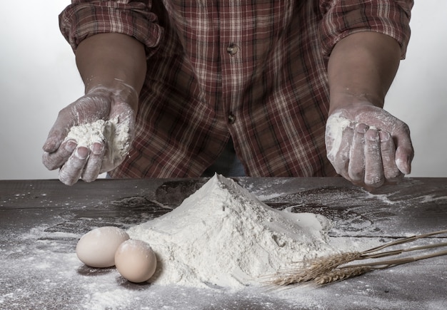 Man bereidt brooddeeg op houten tafel in een bakker close-up