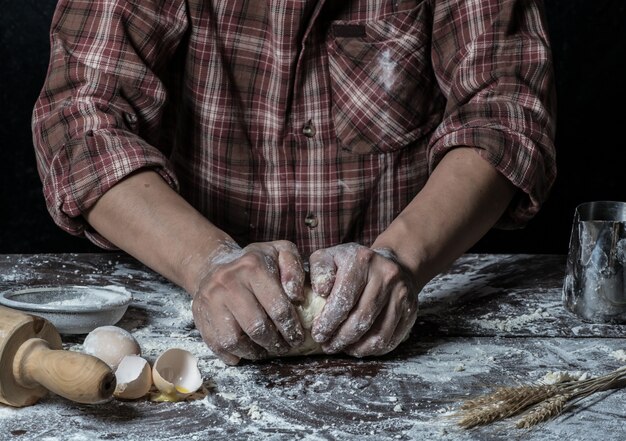 Man bereidt brooddeeg op houten tafel in een bakker close-up