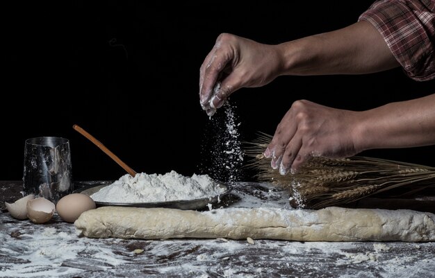 Man bereidt brooddeeg op houten tafel in een bakker close-up