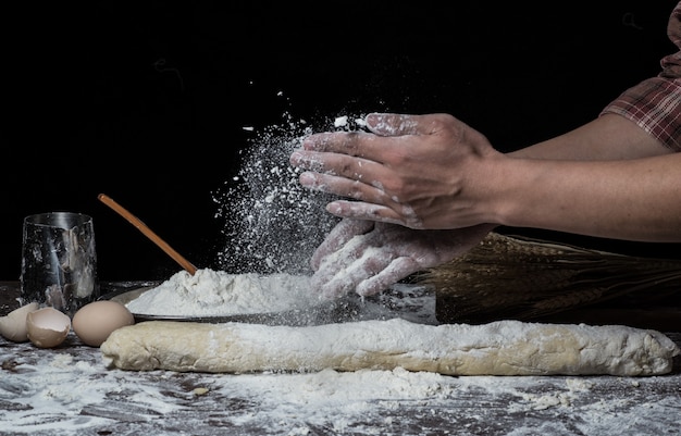 Man bereidt brooddeeg op houten tafel in een bakker close-up