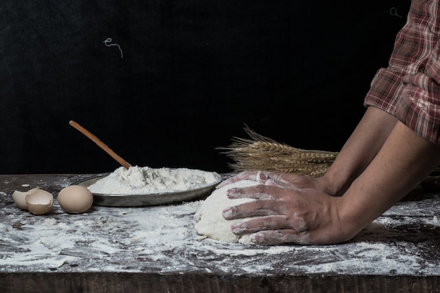 Man bereidt brooddeeg op houten tafel in een bakker close-up