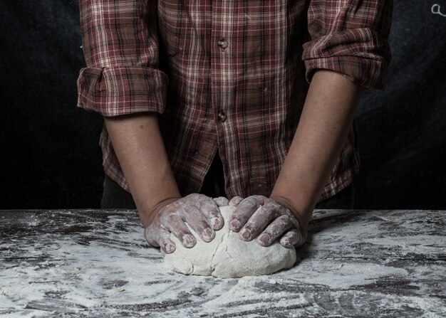 Man bereidt brooddeeg op houten tafel in een bakker close-up