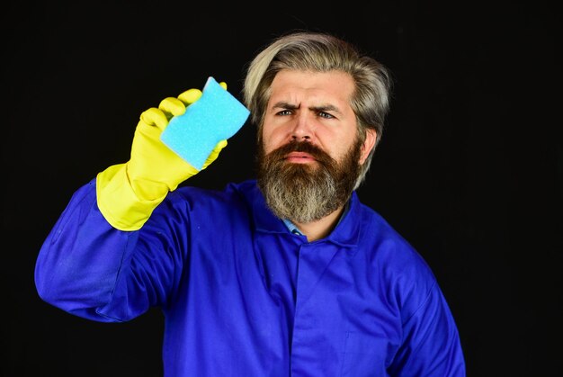 Man beschermende rubberen handschoenen vernietig micro-organismen desinfectie concept bebaarde reiniger in blauw uniform voorjaarsschoonmaak hipster schoon huis virus en microbe virus desinfectie schoon huis