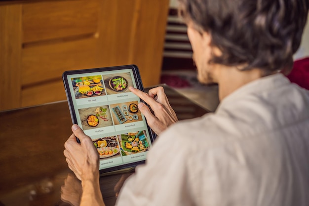 Man bestelt eten voor de lunch online met behulp van tablet