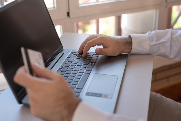 Foto man betaalt met zijn creditcard online met de laptop