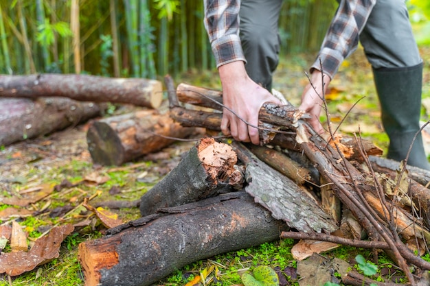 Man bewegende boomstammen op zijn gele kruiwagen Lumberjack Woodcutter met laarzen en vierkant shirt