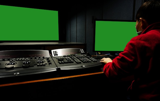man bewerkt video in een donkere studio met behulp van moderne tools en apparatuur voor kleurcorrectie