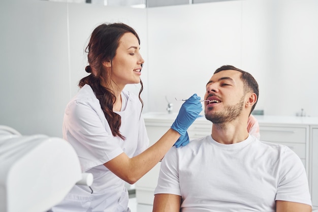 Man bezoekende tandarts in kliniek Conceptie van stomatologie
