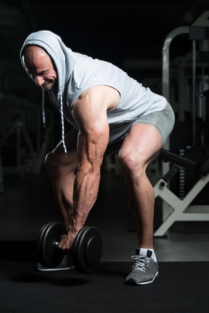 Man biceps trainen in een sportschool halter concentratie krullen