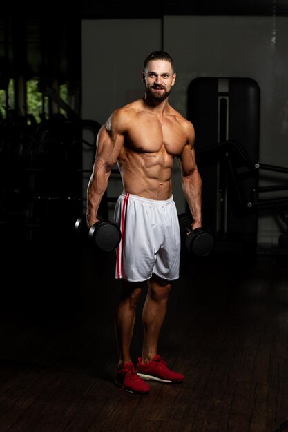 Man biceps trainen in een sportschool halter concentratie krullen
