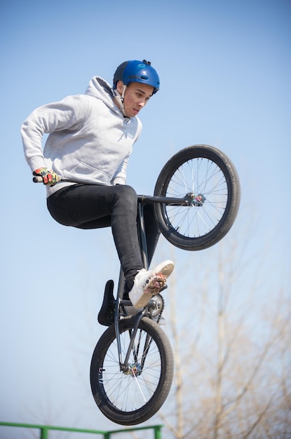 Photo a man on a bicycle balancing on the rear wheel