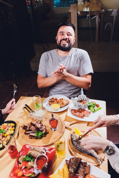 食物と一緒に大きなテーブルで男。