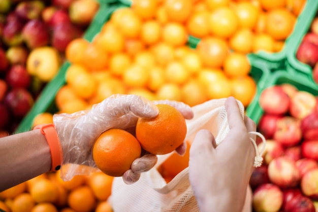 Man bij de supermarkt met eco-tas met producten