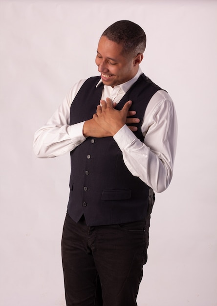 Man in black blazer, white shirt and black pants on a white background making body expressions.
