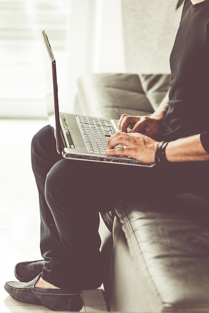 Man in black clothes sitting on laptop