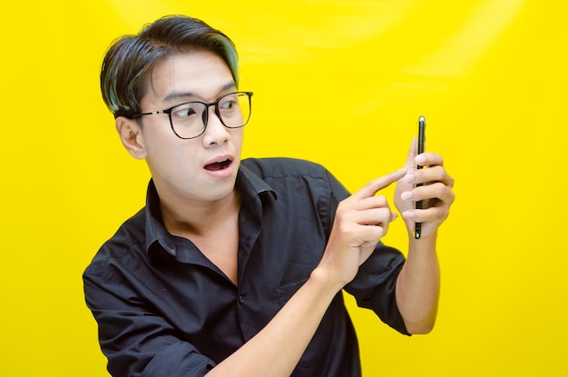 A man in a black shirt is using a cell phone