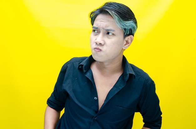 A man in a black shirt with blue hair looks into the camera