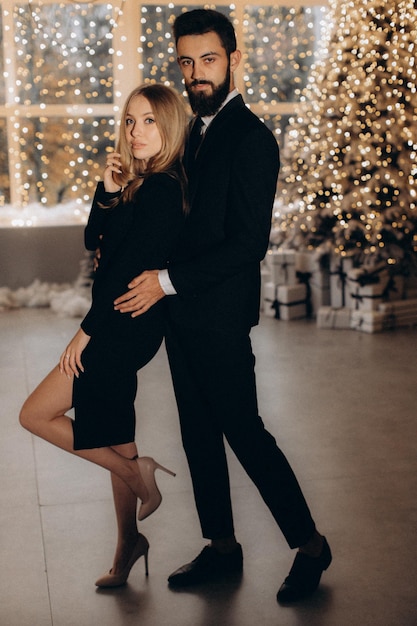 Photo man in black suit and woman in black dress celebrate the new year