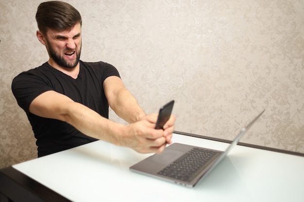 a man in a black tshirt points at his laptop