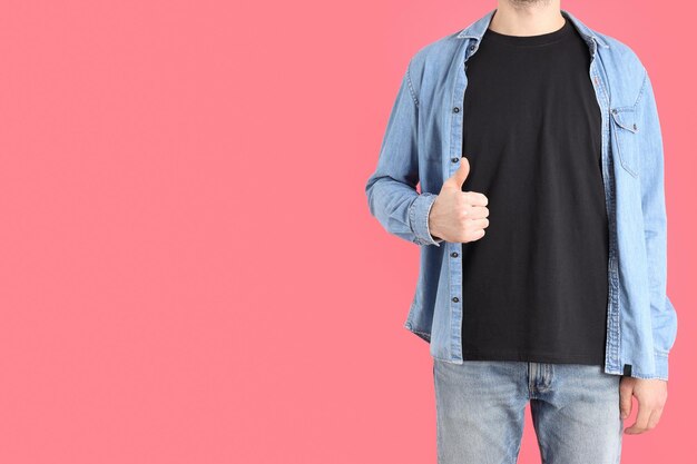 Man in blank black t-shirt on pink background