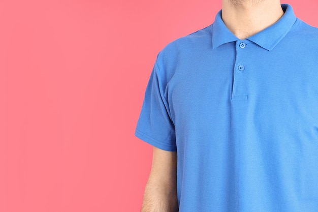 Man in blank blue polo on pink background