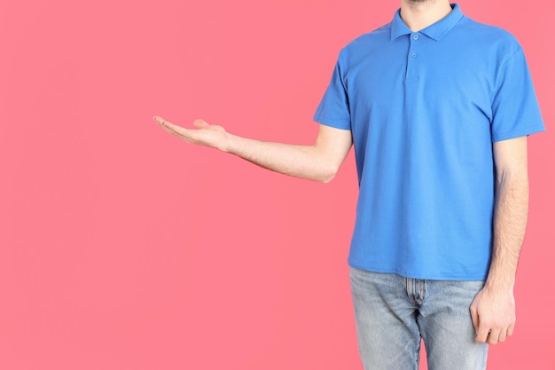 Man in blank blue polo on pink background