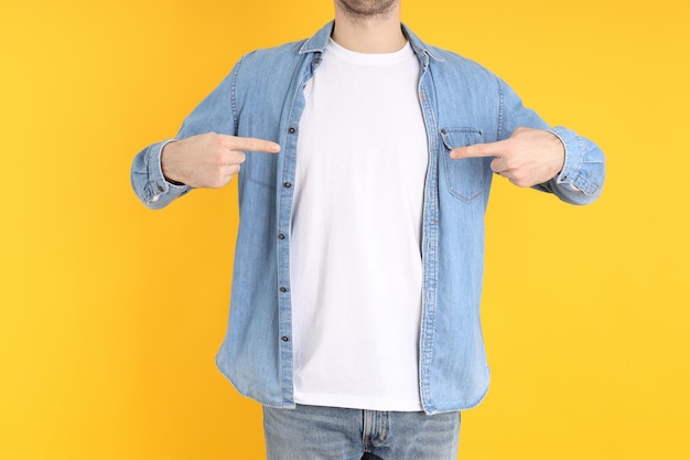 Man in blank t-shirt and in shirt on yellow background