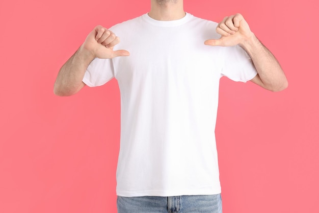 man in blank white t-shirt on pink background