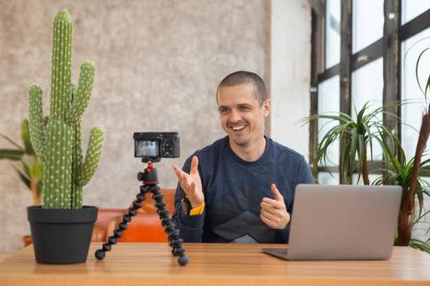 Man blogger die in de camera kijkt en iets vertelt terwijl hij thuis blijft.