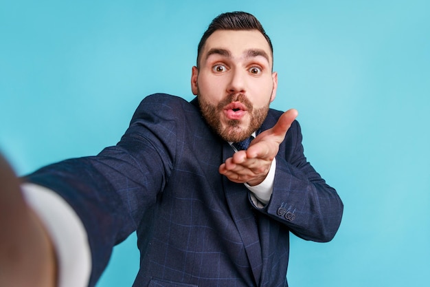 Photo man blowing kiss against blue background