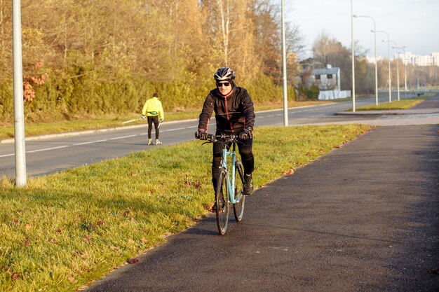 Man on a blue bicycle in the morning cold season goes to work