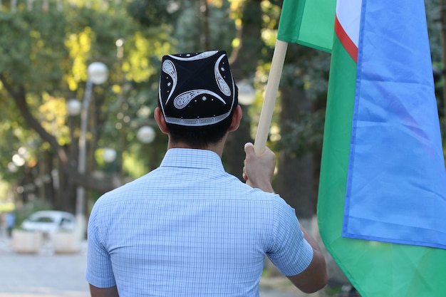 A man in a blue hat holds a green flag.