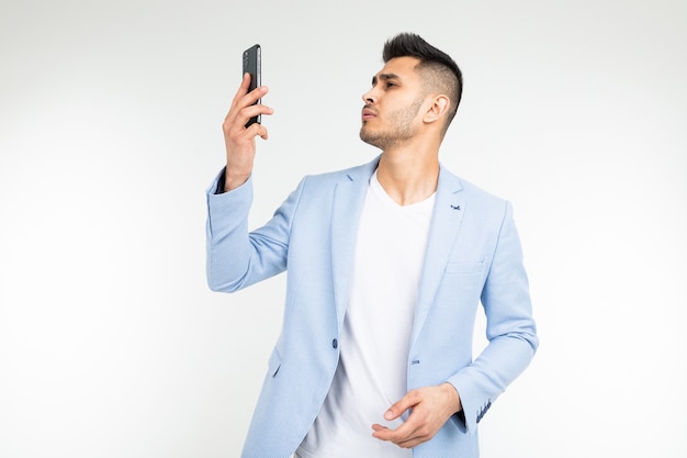 Man in a blue jacket holds a phone with poor mobile connection on a white background.