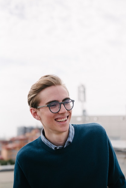 A man in a blue jumper poses.