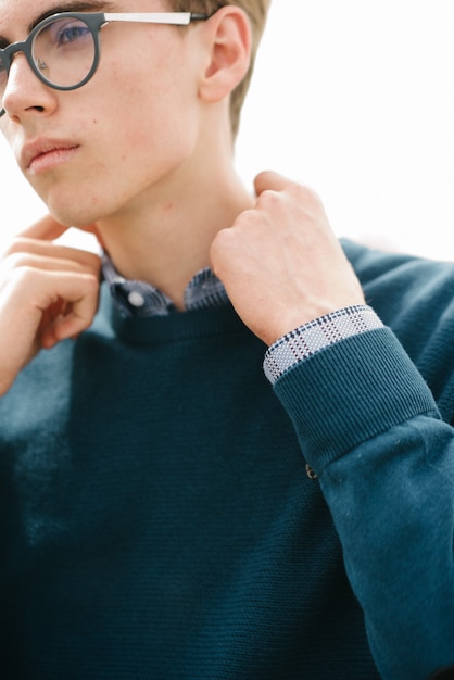 A man in a blue jumper poses.