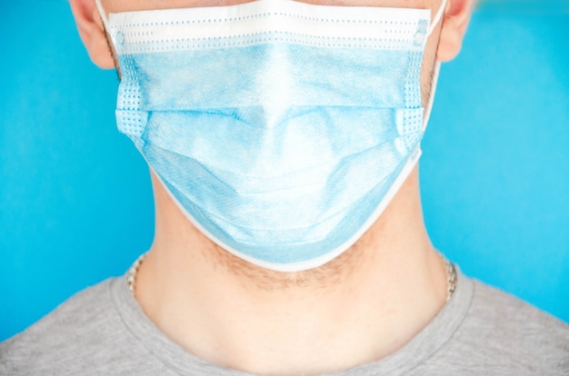 A man in a blue medical mask , sideways. Place for text. Copy Space. Covid-19