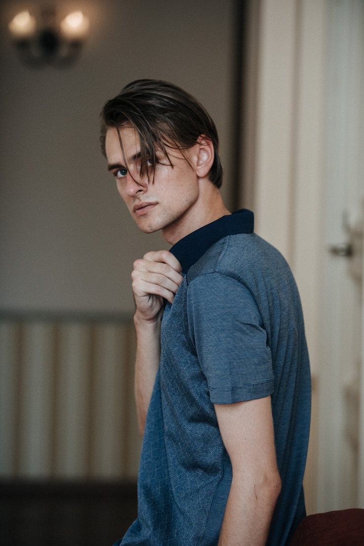 Photo a man in a blue polo poses for menswear advertising. shooting for men's clothing store