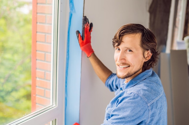 Man in a blue shirt does window installation