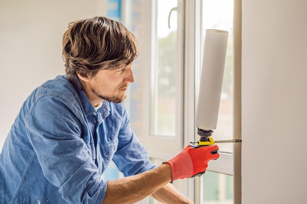 Man in a blue shirt does window installation