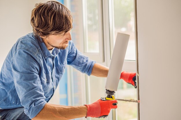 Man in a blue shirt does window installation