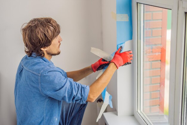 Man in a blue shirt does window installation