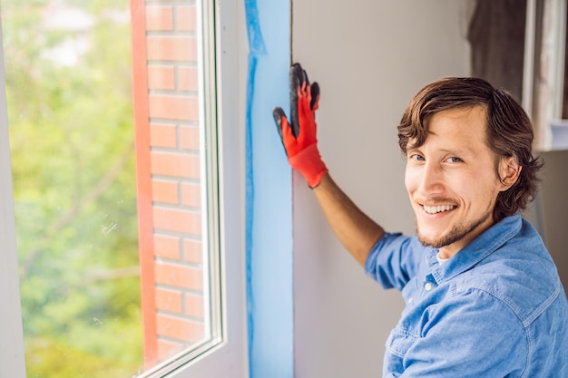 Man in a blue shirt does window installation