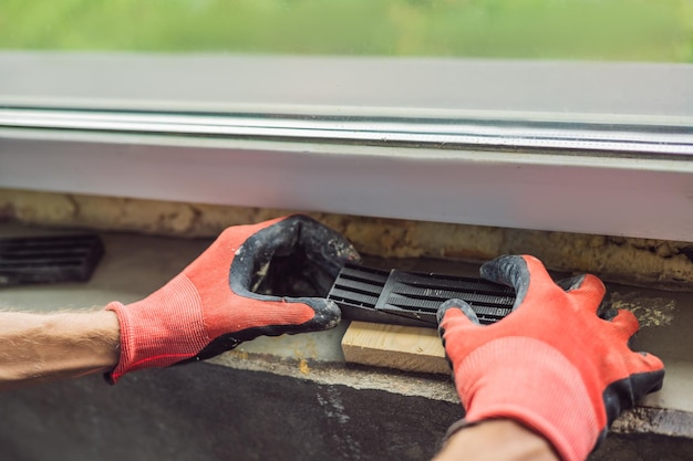 Man in a blue shirt does window installation