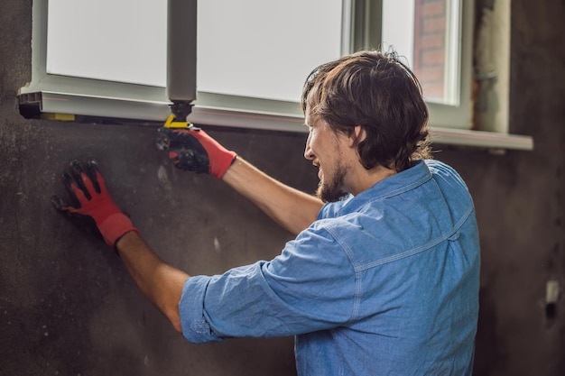 Man in a blue shirt does window installation